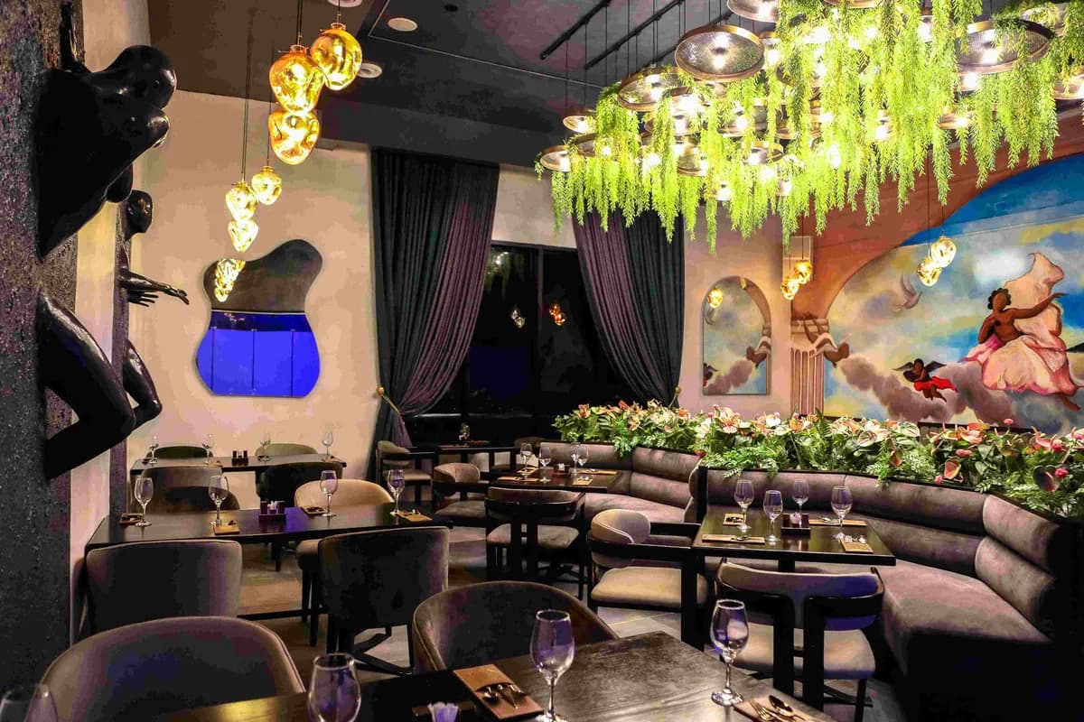 The Paradis Lagos dining room, framed by drapes and hanging greenery