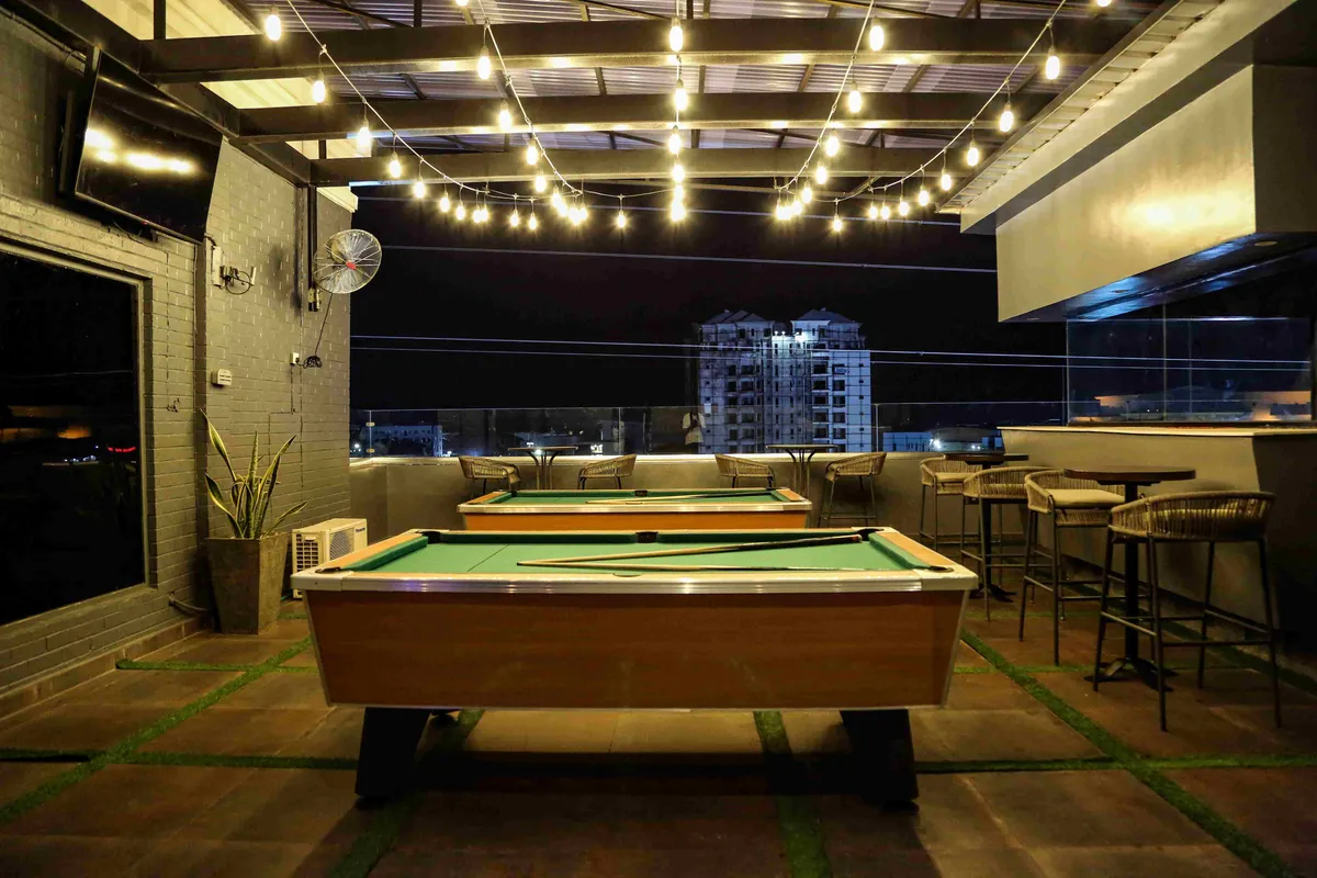 The rooftop pool table at Paradis Lagos, strung with festoon lights