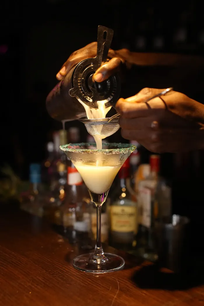 A bartender pouring a handcrafted cocktail