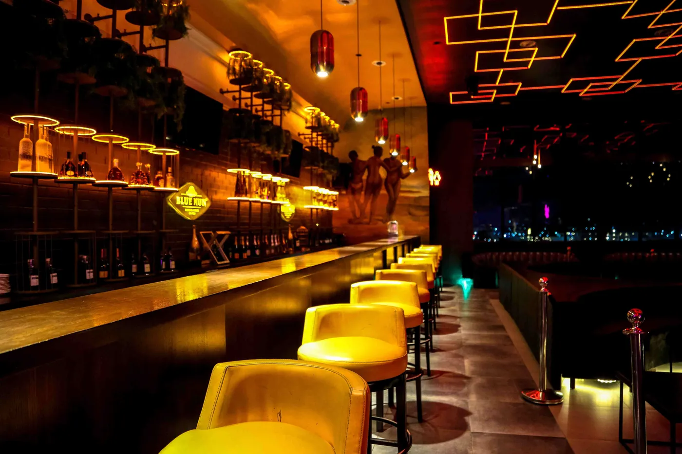 The bar at Paradis Lagos, lined with yellow velvet stools
